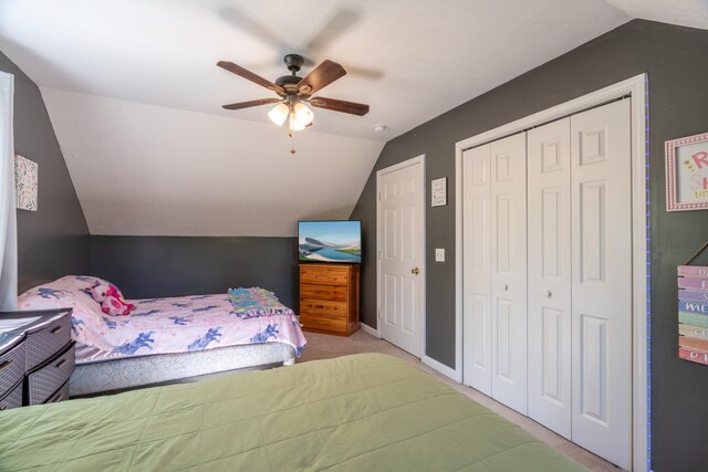 carpeted bedroom featuring baseboards, lofted ceiling, a closet, and ceiling fan