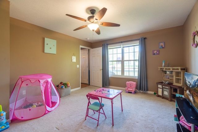 recreation room featuring carpet, baseboards, and ceiling fan