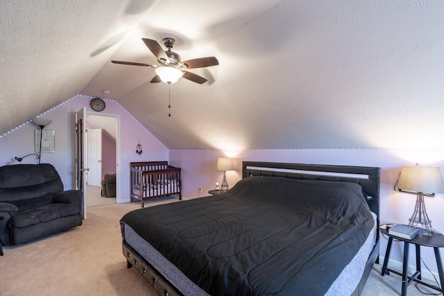 bedroom with light colored carpet, vaulted ceiling, a ceiling fan, and a textured ceiling