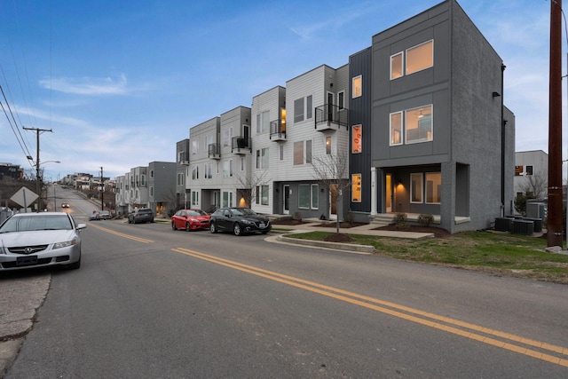 view of road featuring a residential view, curbs, street lights, and sidewalks