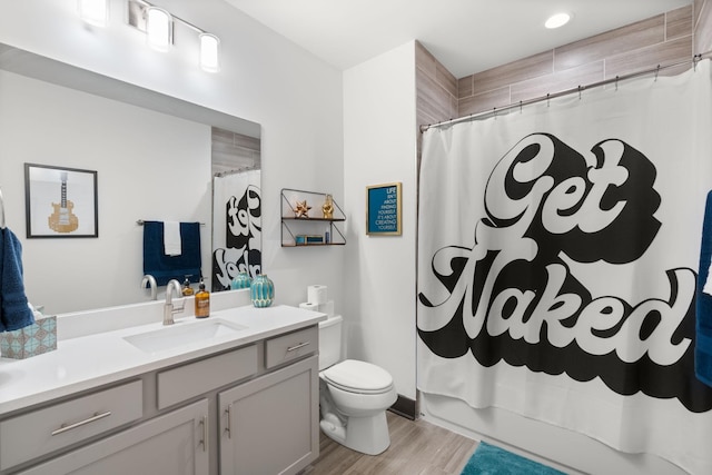 bathroom featuring shower / tub combo with curtain, wood finished floors, toilet, and vanity