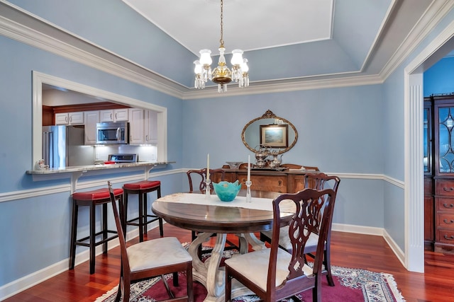 dining room featuring crown molding, an inviting chandelier, dark wood-style flooring, baseboards, and a raised ceiling