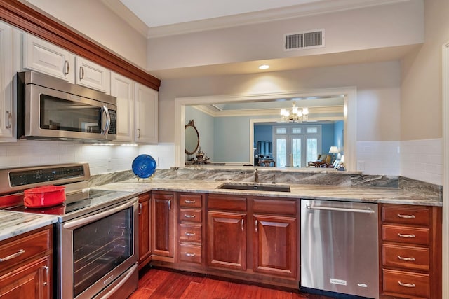 kitchen with crown molding, french doors, stainless steel appliances, a sink, and visible vents