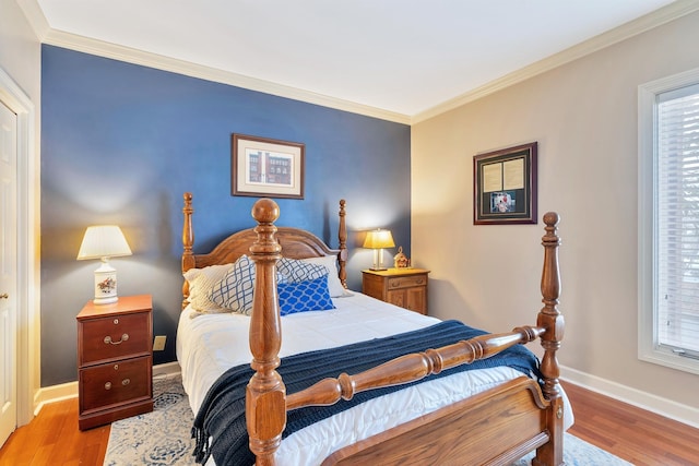 bedroom featuring baseboards, crown molding, and wood finished floors