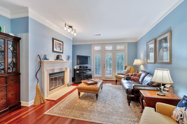 living room with ornamental molding, visible vents, a high end fireplace, and dark wood finished floors