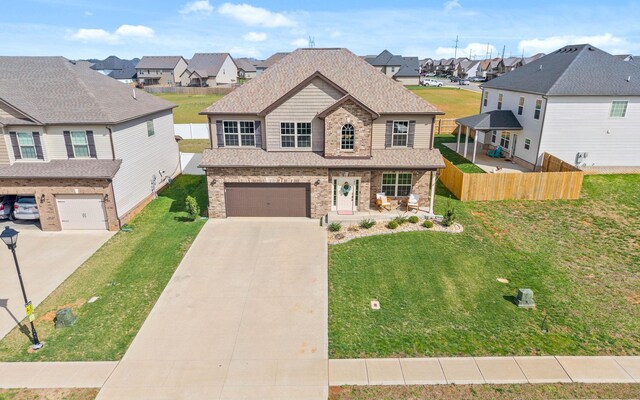 185 Kildeer Dr, Clarksville, TN 37040 - view of front facade with concrete driveway, fence, an attached garage, a residential view, and a front yard