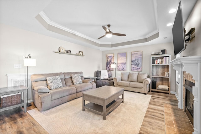 185 Kildeer Dr, Clarksville, TN 37040 - living area with a tray ceiling, wood finished floors, a fireplace with flush hearth, and ceiling fan
