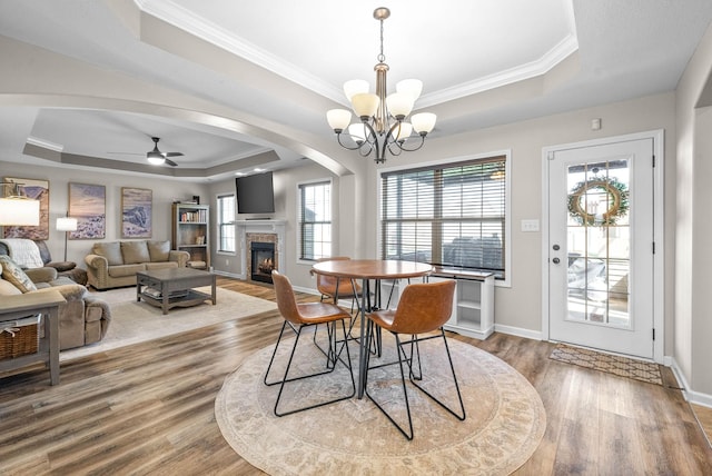185 Kildeer Dr, Clarksville, TN 37040 - dining room featuring ornamental molding, wood finished floors, a raised ceiling, ceiling fan with notable chandelier, and a glass covered fireplace