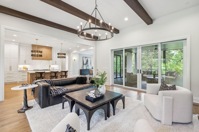 living area featuring a notable chandelier, beam ceiling, light wood finished floors, baseboards, and recessed lighting