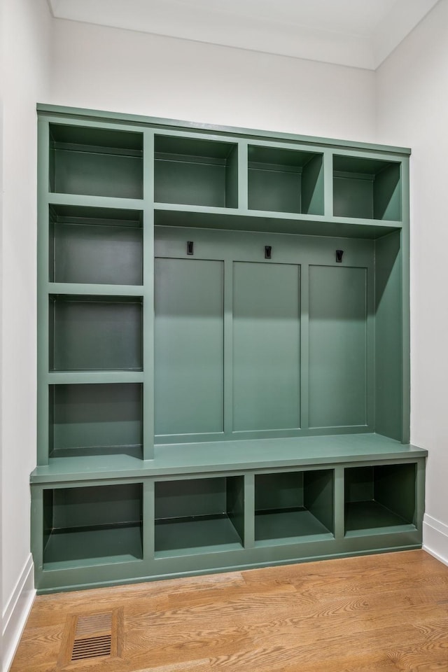 mudroom featuring visible vents, wood finished floors, and ornamental molding