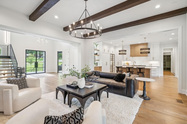 living room with recessed lighting, light wood-type flooring, baseboards, a chandelier, and beamed ceiling