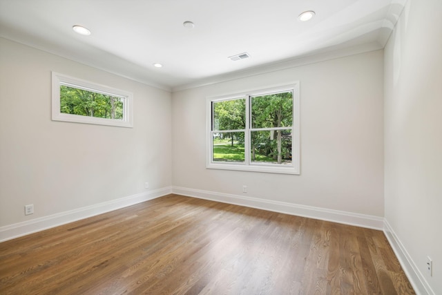 empty room featuring baseboards, visible vents, recessed lighting, and wood finished floors
