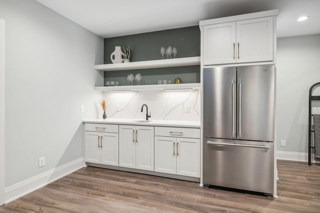 kitchen featuring baseboards, high end refrigerator, and dark wood-type flooring