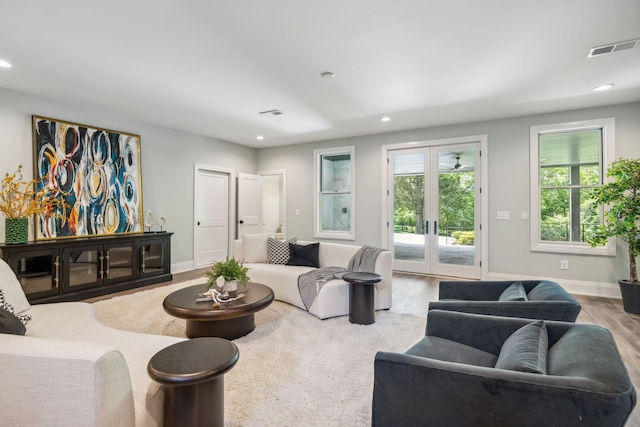 living area with recessed lighting, french doors, baseboards, visible vents, and wood finished floors