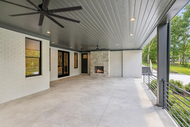 view of patio / terrace featuring an outdoor stone fireplace and ceiling fan