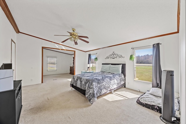 carpeted bedroom featuring ornamental molding and a ceiling fan