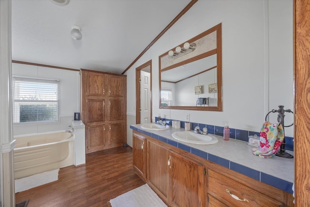 full bath featuring a bath, wood finished floors, ornamental molding, and a sink