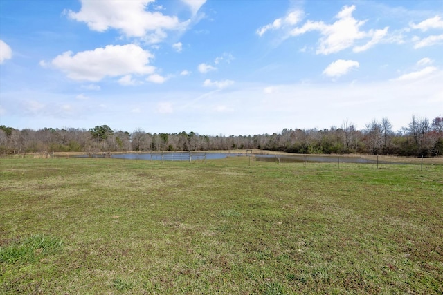 view of yard with a forest view and a water view
