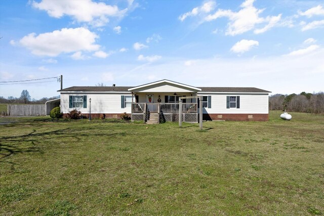 rear view of property featuring a porch, crawl space, a detached carport, and a lawn