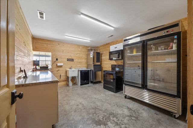interior space featuring concrete flooring, a sink, wood walls, and visible vents