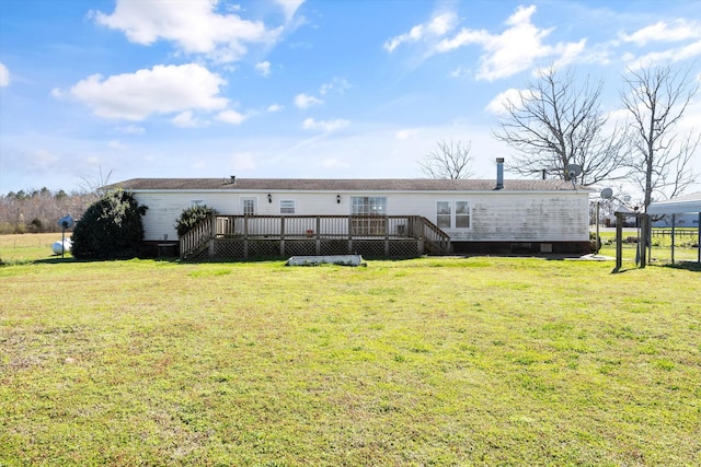 rear view of property featuring a lawn and a deck