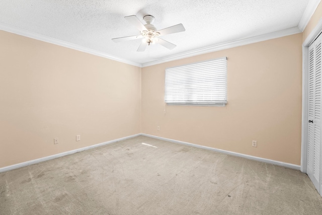 unfurnished bedroom featuring crown molding, baseboards, a textured ceiling, carpet floors, and a closet