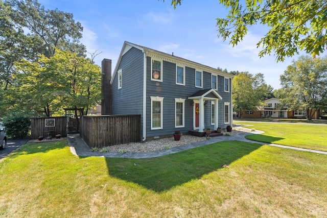 colonial inspired home featuring fence and a front yard
