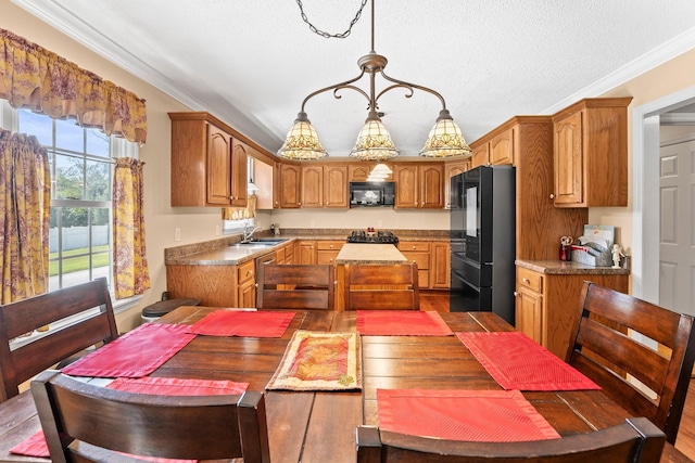kitchen with a center island, black appliances, ornamental molding, and a sink
