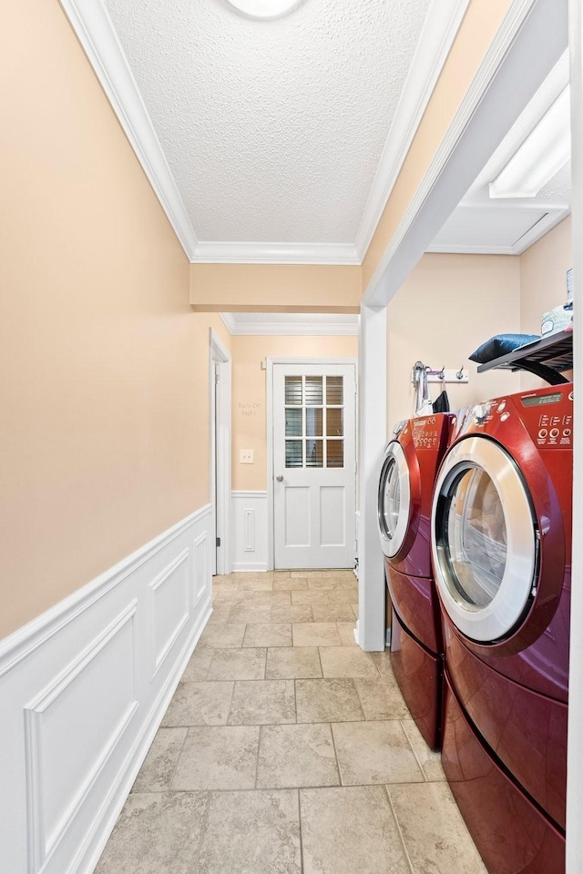 laundry area with washer and clothes dryer, wainscoting, laundry area, and a textured ceiling
