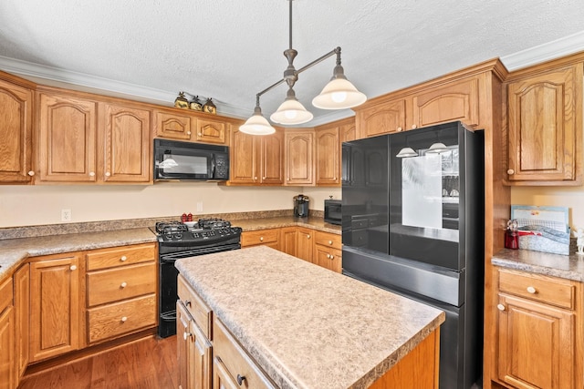 kitchen with black appliances, wood finished floors, a textured ceiling, a center island, and decorative light fixtures