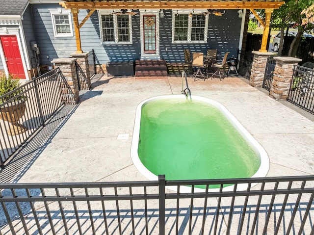 view of pool with fence, entry steps, a fenced in pool, a ceiling fan, and a patio area