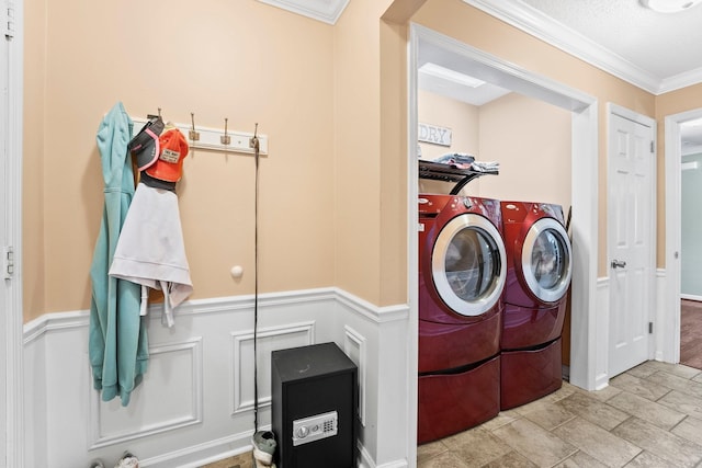 laundry room featuring a decorative wall, independent washer and dryer, ornamental molding, laundry area, and wainscoting