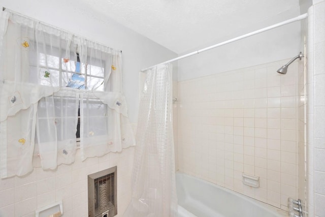 full bath featuring heating unit, shower / bath combo, and a textured ceiling