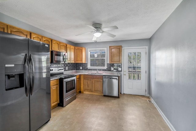 106 Hampton Dr, La Vergne, TN 37086 - kitchen featuring baseboards, ceiling fan, stainless steel appliances, tasteful backsplash, and a sink