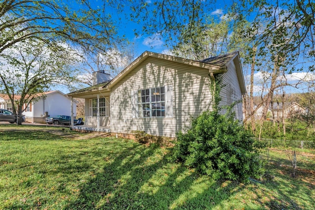 106 Hampton Dr, La Vergne, TN 37086 - view of home's exterior with fence, a yard, and a chimney