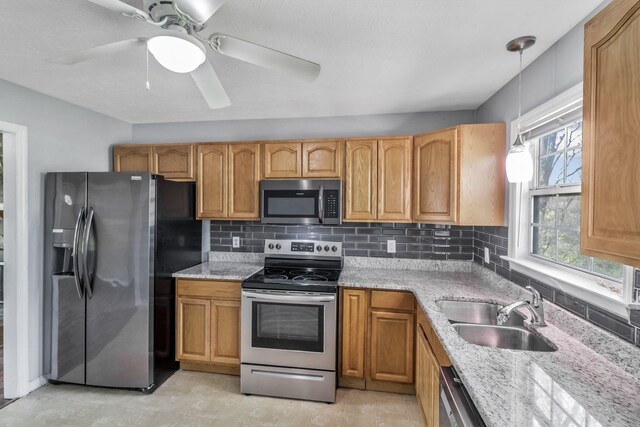 106 Hampton Dr, La Vergne, TN 37086 - kitchen featuring light stone countertops, stainless steel appliances, tasteful backsplash, a sink, and decorative light fixtures