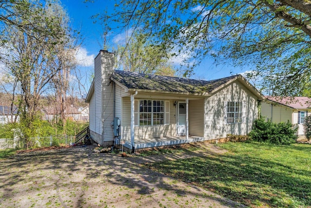 106 Hampton Dr, La Vergne, TN 37086 - view of front facade with a front yard, a porch, fence, and a chimney