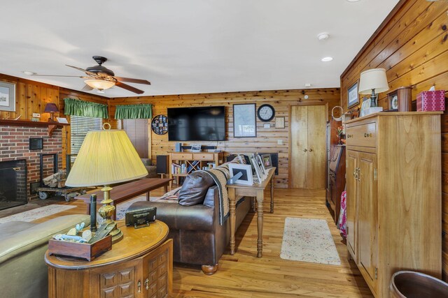 9395 Greenbriar Rd, Waverly, TN 37185 - living room featuring wooden walls, a ceiling fan, light wood finished floors, and a brick fireplace