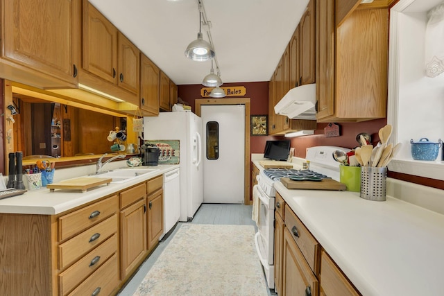 9395 Greenbriar Rd, Waverly, TN 37185 - kitchen featuring under cabinet range hood, white appliances, a sink, light countertops, and brown cabinetry
