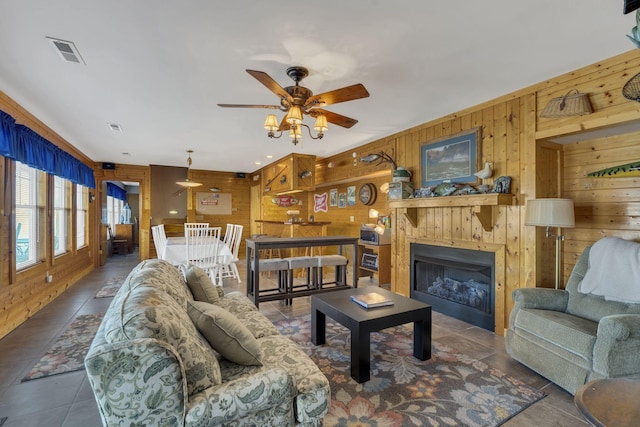 9395 Greenbriar Rd, Waverly, TN 37185 - living room featuring wooden walls, ceiling fan, tile patterned flooring, and a fireplace