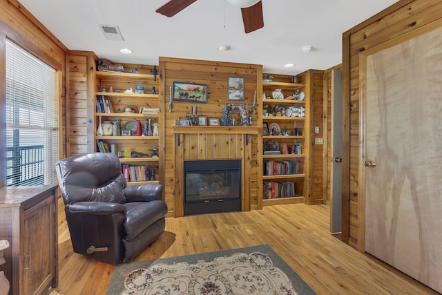 9395 Greenbriar Rd, Waverly, TN 37185 - living area featuring a glass covered fireplace, wood finished floors, ceiling fan, wood walls, and recessed lighting