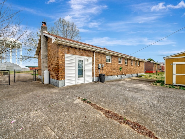 440 Appleton Dr, Clarksville, TN 37042 - back of property featuring a gate, fence, a chimney, brick siding, and an outdoor structure