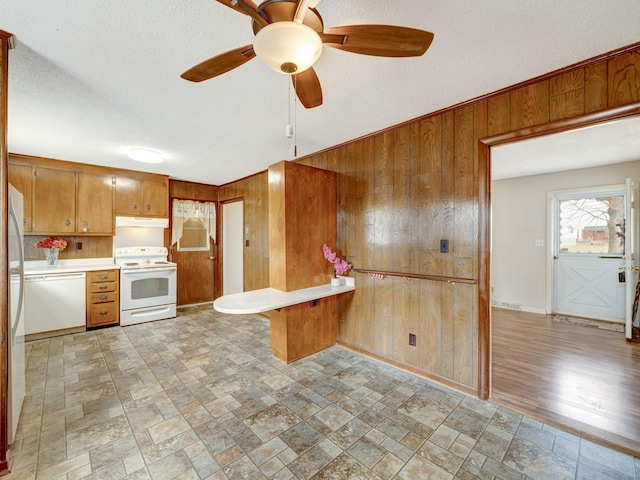 440 Appleton Dr, Clarksville, TN 37042 - kitchen featuring light countertops, wooden walls, brown cabinets, under cabinet range hood, and white appliances