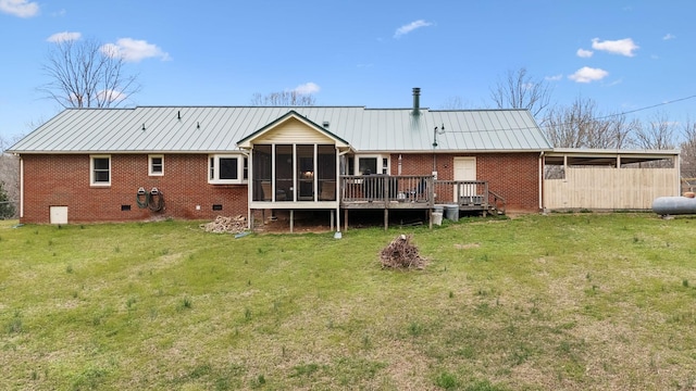 rear view of property featuring brick siding, a sunroom, a standing seam roof, and a yard