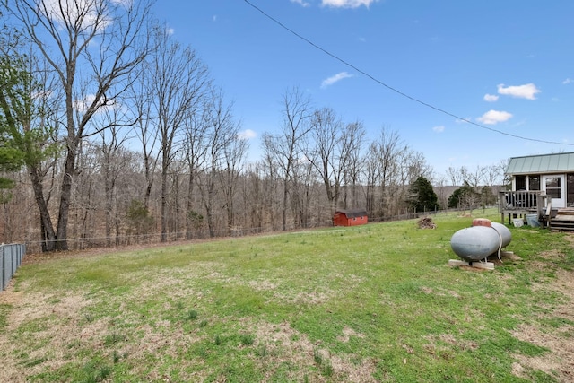 view of yard featuring fence and a wooded view