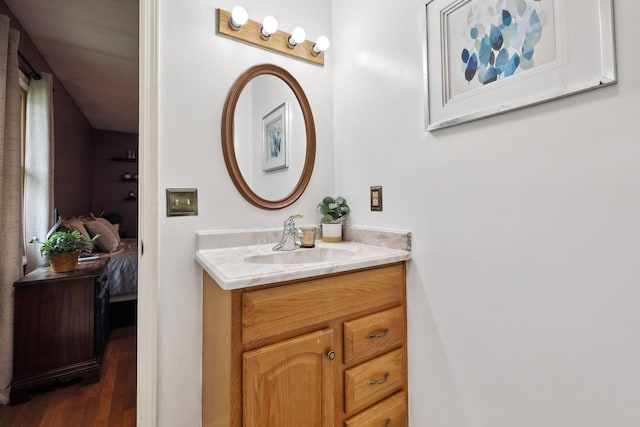ensuite bathroom featuring vanity, connected bathroom, and wood finished floors