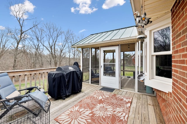 wooden terrace featuring grilling area and a sunroom
