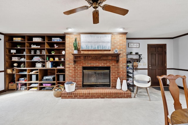 carpeted living room with a brick fireplace, crown molding, baseboards, and ceiling fan