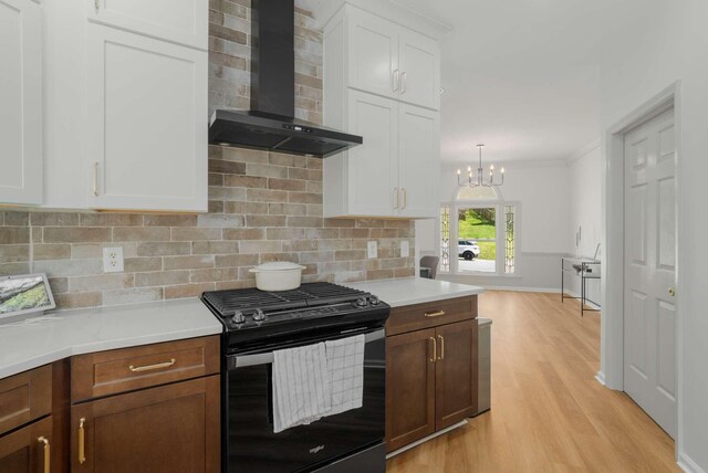 6525 Chessington Dr, Nashville, TN 37221 - kitchen featuring black gas range oven, light countertops, wall chimney range hood, and backsplash