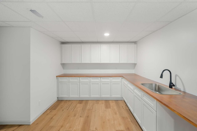 6525 Chessington Dr, Nashville, TN 37221 - kitchen with a sink, light wood-style flooring, baseboards, white cabinets, and a drop ceiling